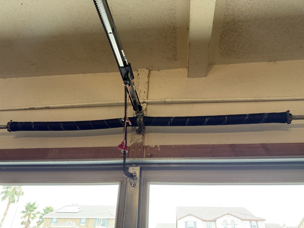 Torsion spring mounted on shaft above garage door