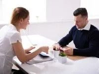 Woman and Man at a Table, Looking at Papers — Dwyer Law Group in Surfers Paradise, QLD
