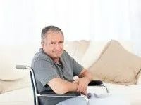 Man in Wheelchair Smiling in Front of a Sofa — Dwyer Law Group in Surfers Paradise, QLD