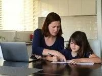 Woman Helping a Child With Homework at a Table — Dwyer Law Group in Surfers Paradise, QLD