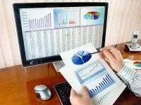 Person Analyzes Financial Charts on Computer and Paper — Dwyer Law Group in Surfers Paradise, QLD