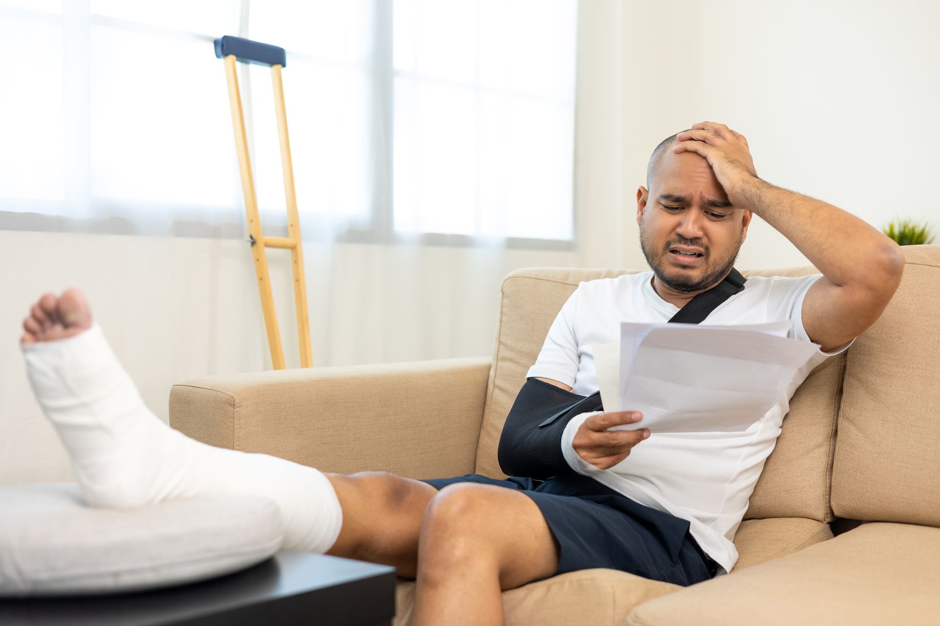 Man With Leg and Arm Casts, Holding Papers — Dwyer Law Group in Surfers Paradise, QLD