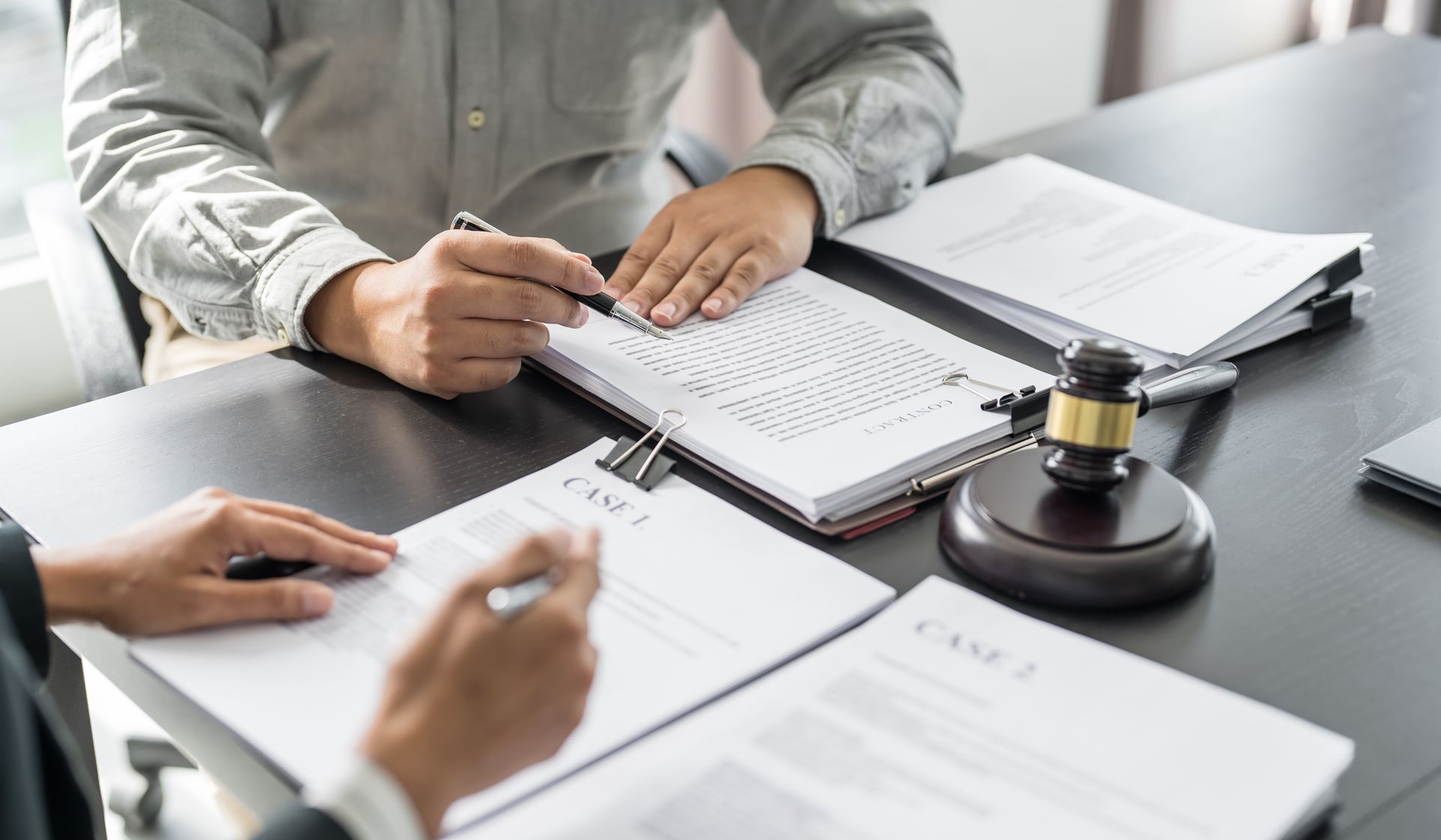 Two People Signing Documents at a Desk, Gavel Present — Dwyer Law Group in Surfers Paradise, QLD