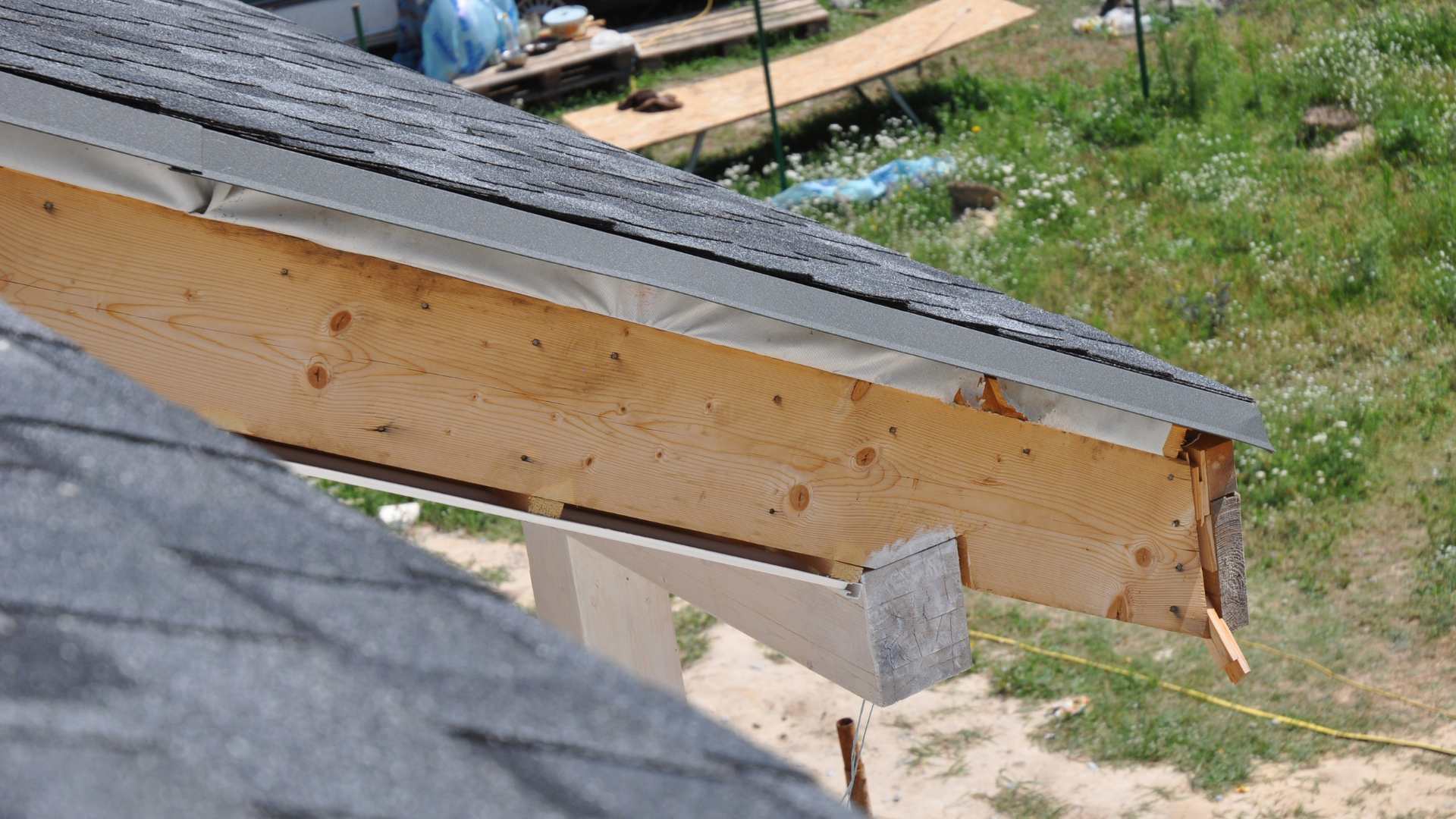 Partially built wooden roof beam with shingles on a house under construction