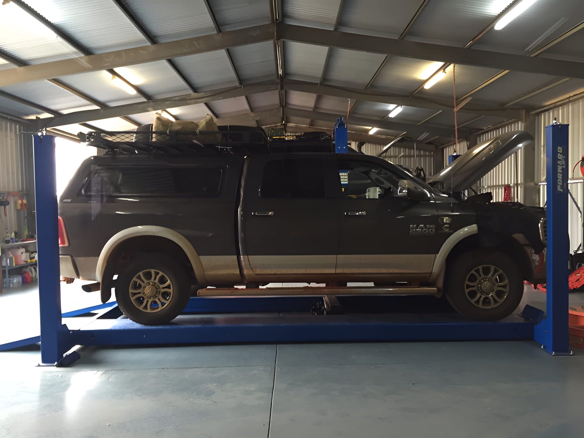 A Truck With The Hood Up Is On A Lift In A Garage — Red Central Towing & Recovery In Alice Springs, NT