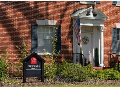 Brick building with white portico, American flag, and sign reading