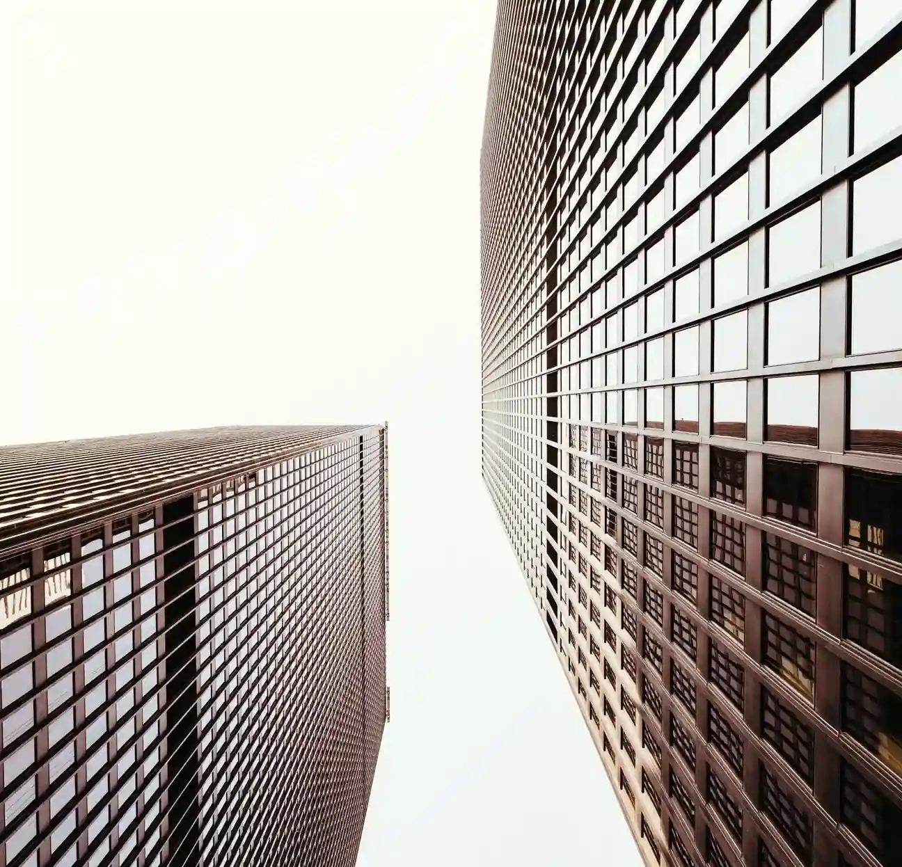 Visão de baixo de 2 grandes prédios.