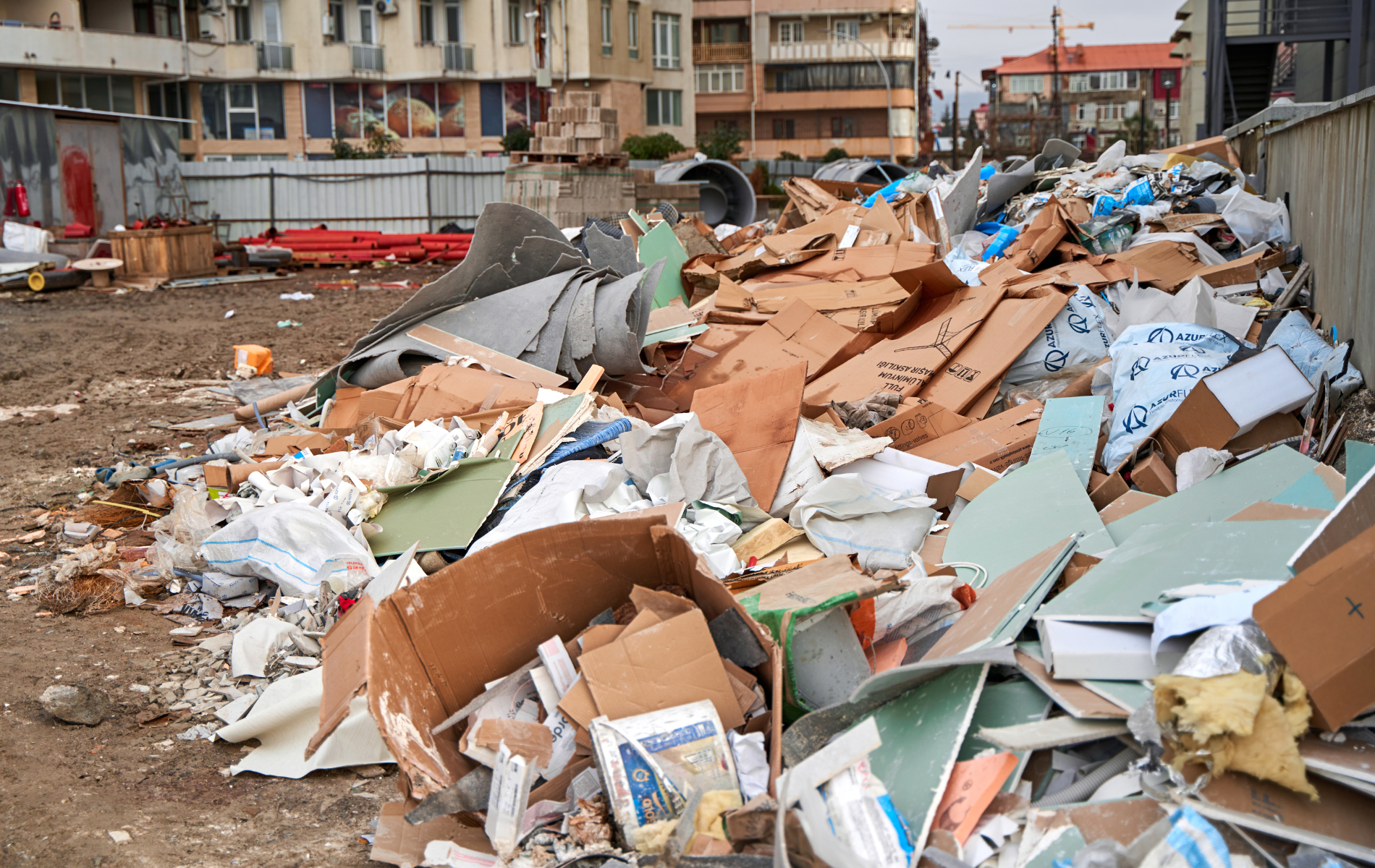 A pile of trash is sitting on the ground in front of a building.