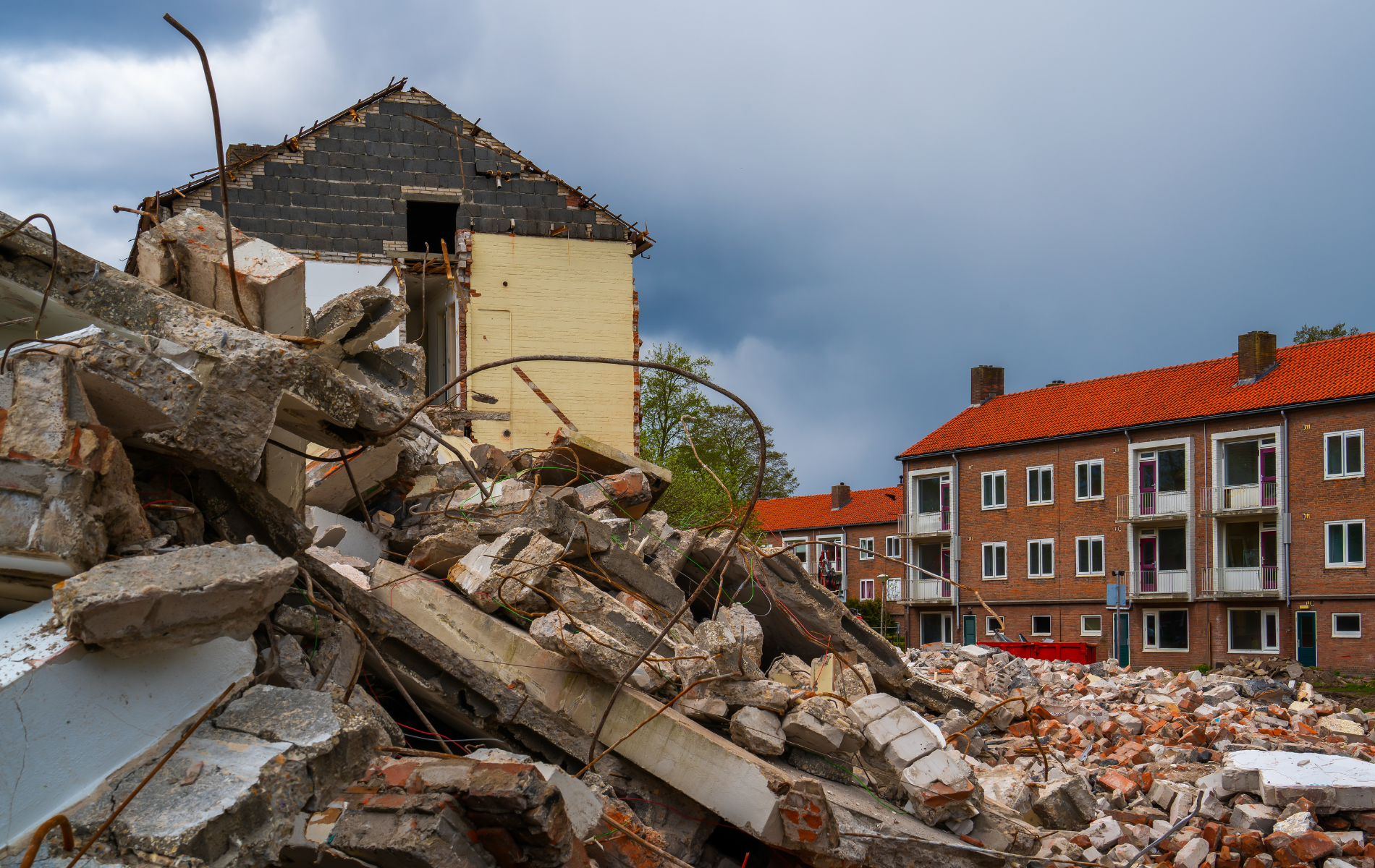 A pile of rubble is sitting in front of a brick building.