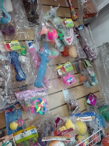 Una pared de exhibición en una tienda, repleta de juguetes coloridos, objetos sensoriales para estimular la mente y artículos novedosos empaquetados individualmente en plástico.