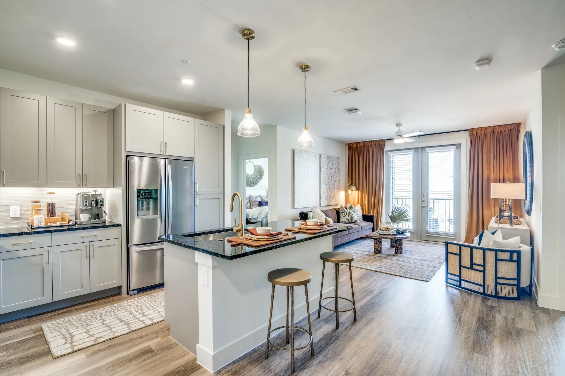 Open-concept kitchen and living area with modern finishes, including stainless steel appliances and a granite island.