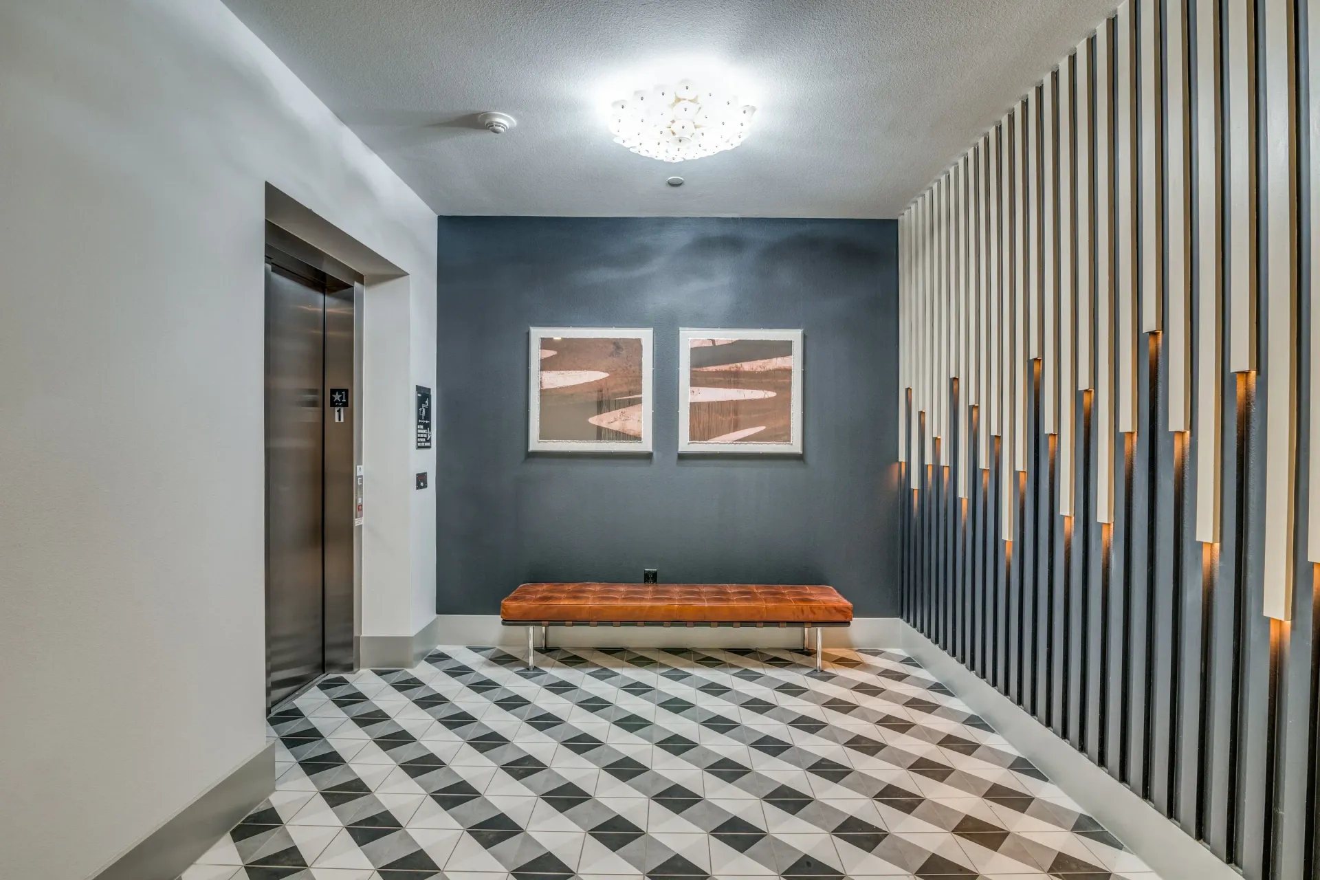Hallway with elevator, artwork, and seating