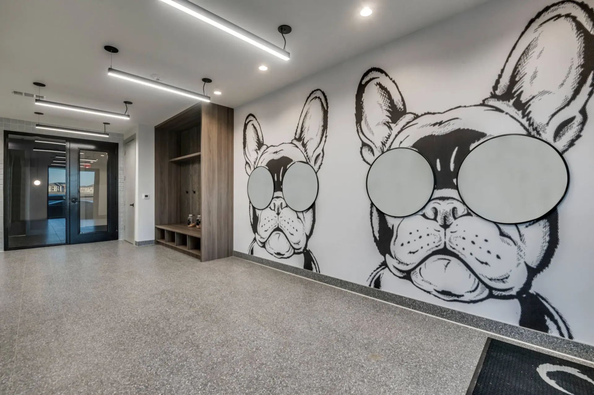 Interior hallway with a large mural of two French bulldogs wearing sunglasses.