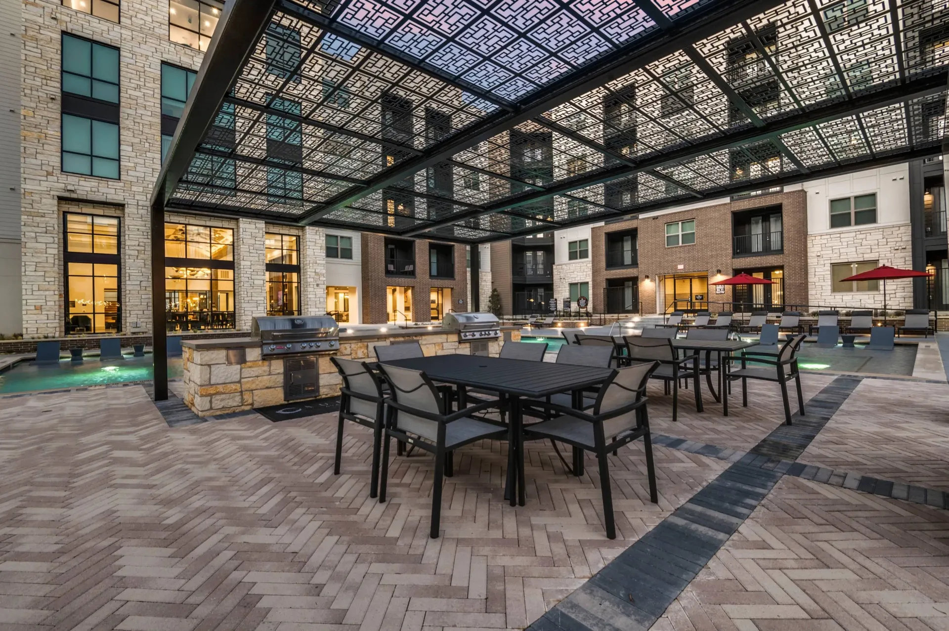 Outdoor patio with seating, grills, and pool.