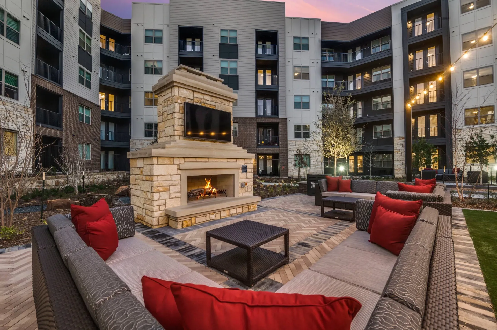 Outdoor lounge area with fireplace and seating.