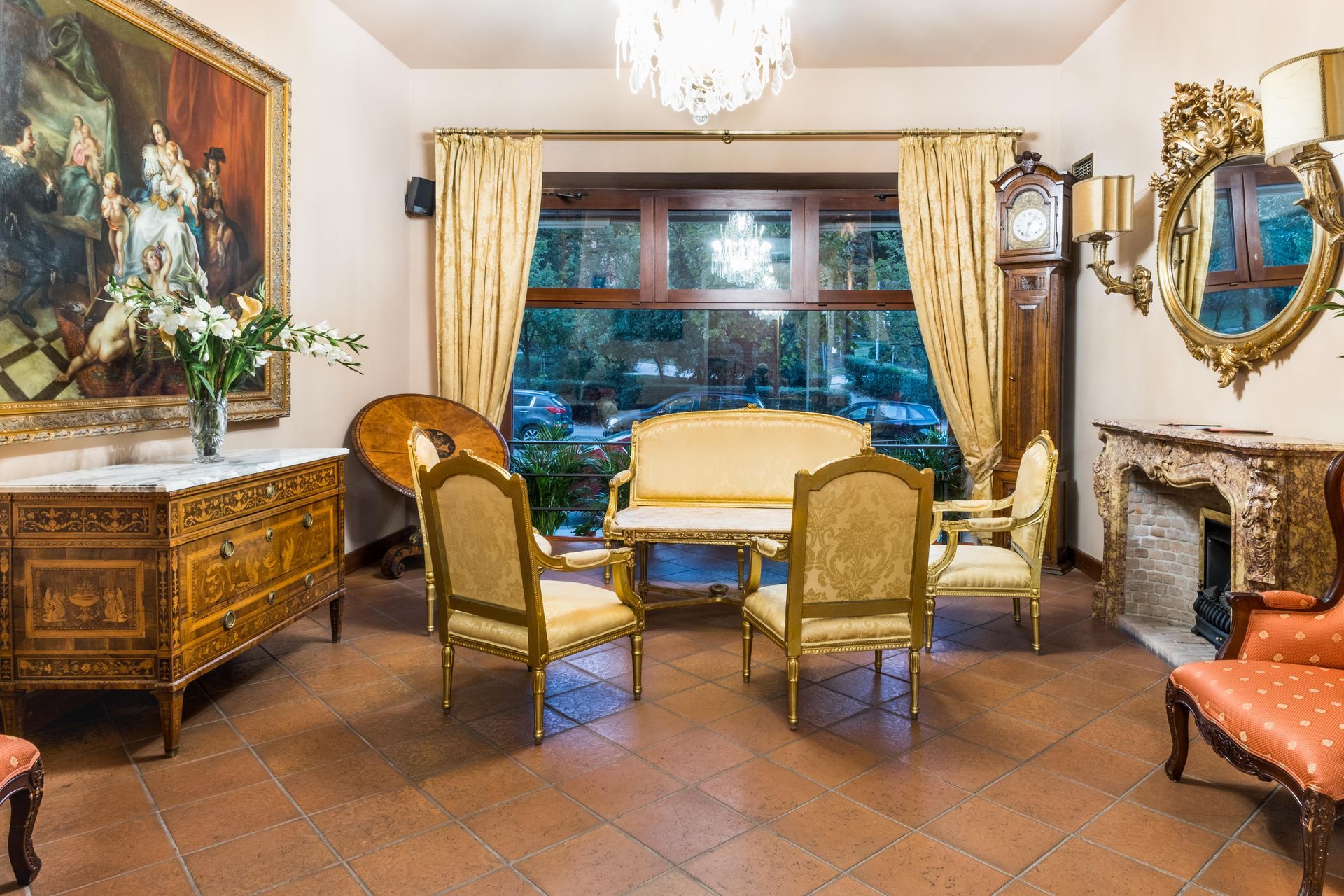 Elegantes Wohnzimmer mit kunstvollen Möbeln, großem Fenster, antiker Uhr und Kronleuchter.