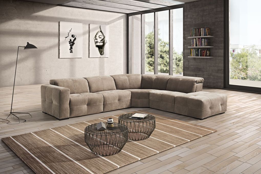 Soggiorno moderno con divano componibile beige, tappeto, lampada da terra, quadri e ampie finestre.
