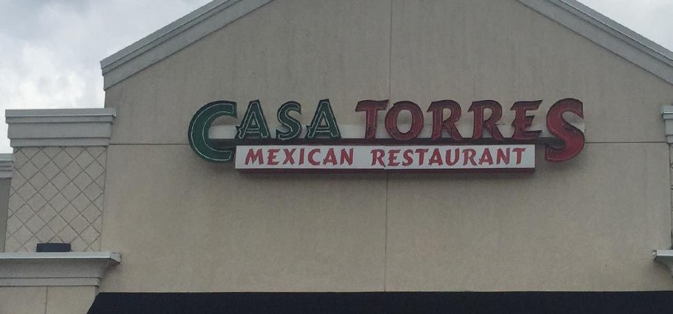 Sign for Casa Torres Mexican Restaurant, with green "CASA" and red "TORRES" letters, and "MEXICAN RESTAURANT" below in a white box.
