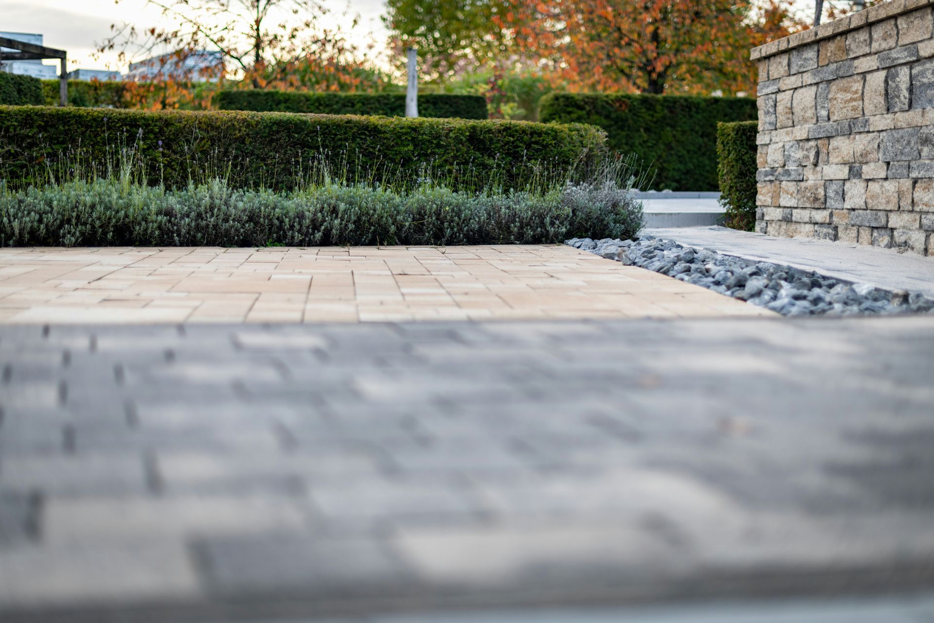 Stone patio with hedge and stone wall in a landscaped garden