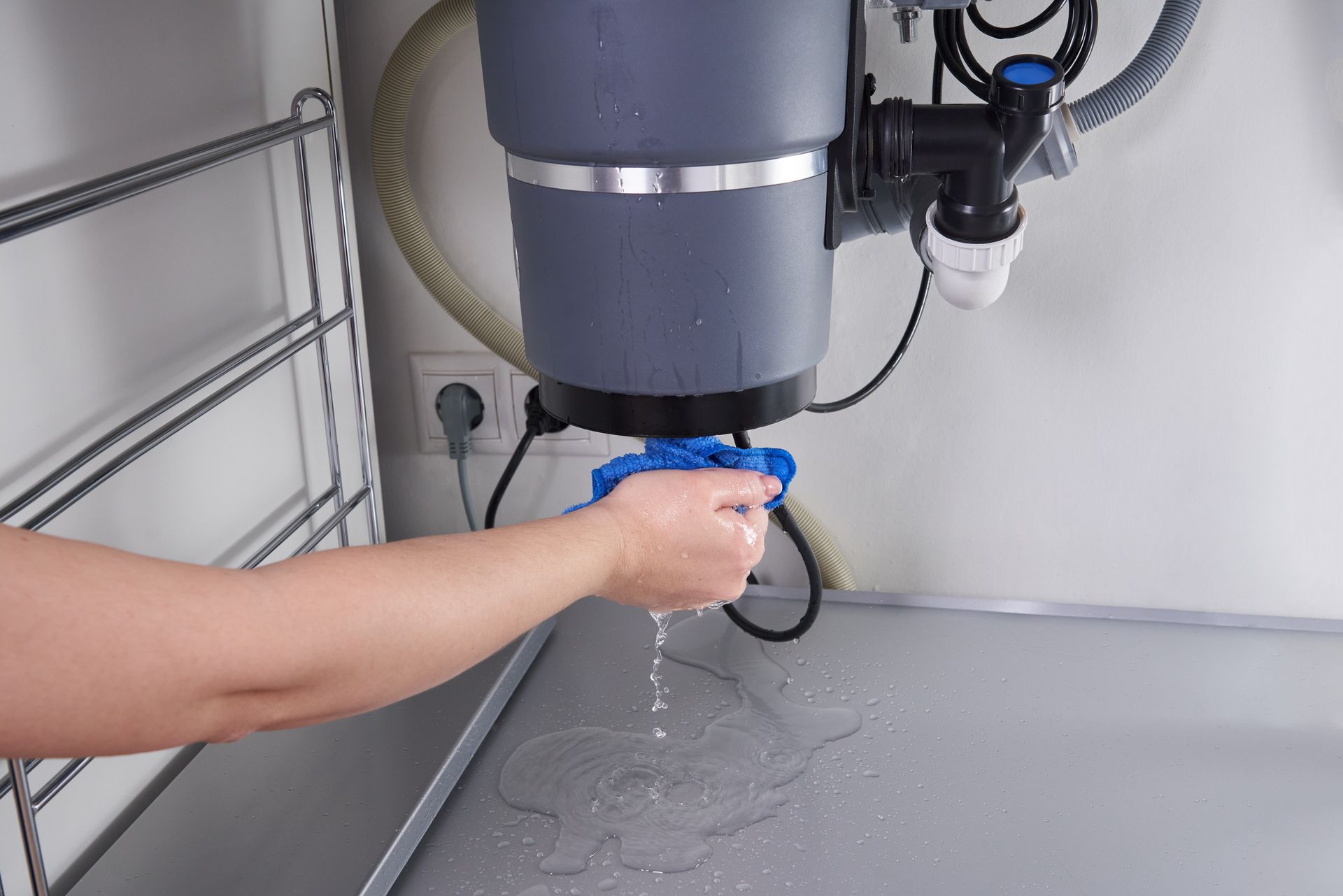 Person filling a transparent cup at a wall-mounted water dispenser in a utility room Person filling a transparent cup at a wall-mounted water dispenser in a utility room