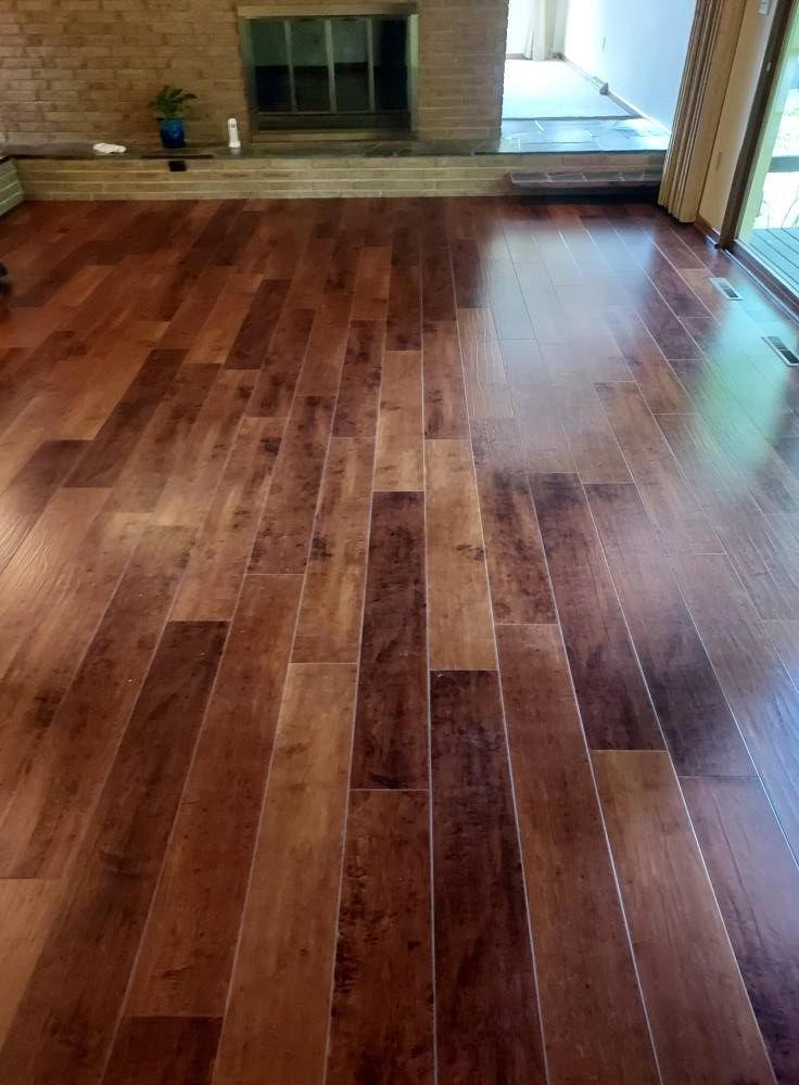 Glossy hardwood floor in an empty room with steps and a doorway at the back
