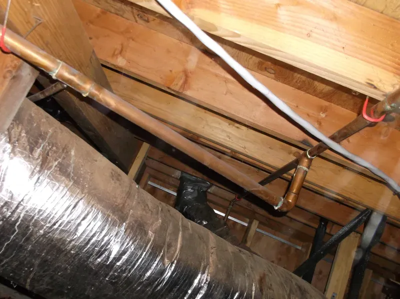 A copper pipe is hanging from the ceiling of a building