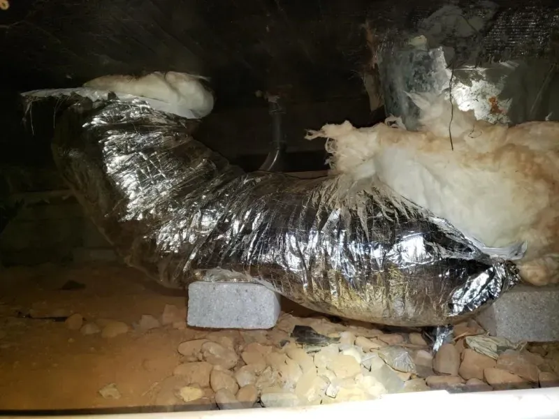 A duct in a basement with a lot of insulation on it