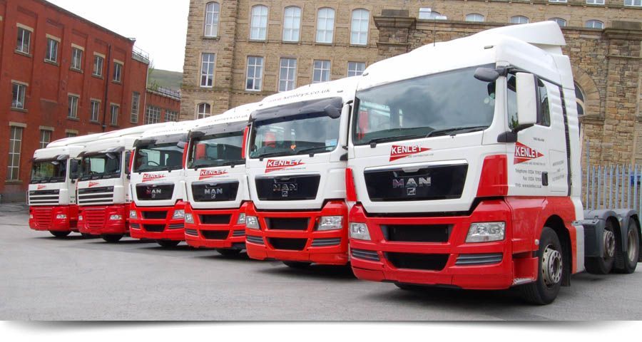 a row of red and white trucks parked in front of a building