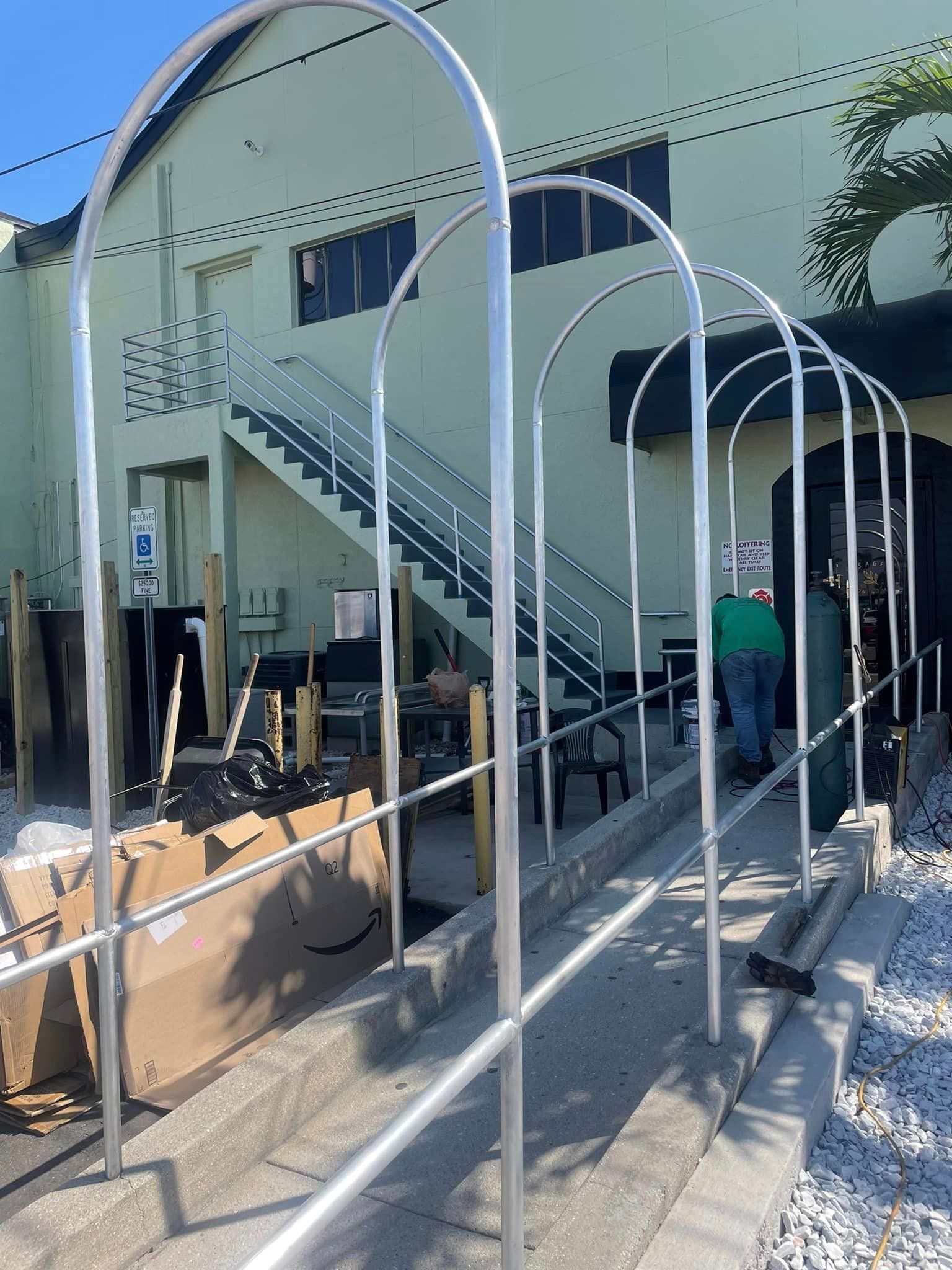 Ramped walkway with arched supports in front of a building. Person walking on the ramp.