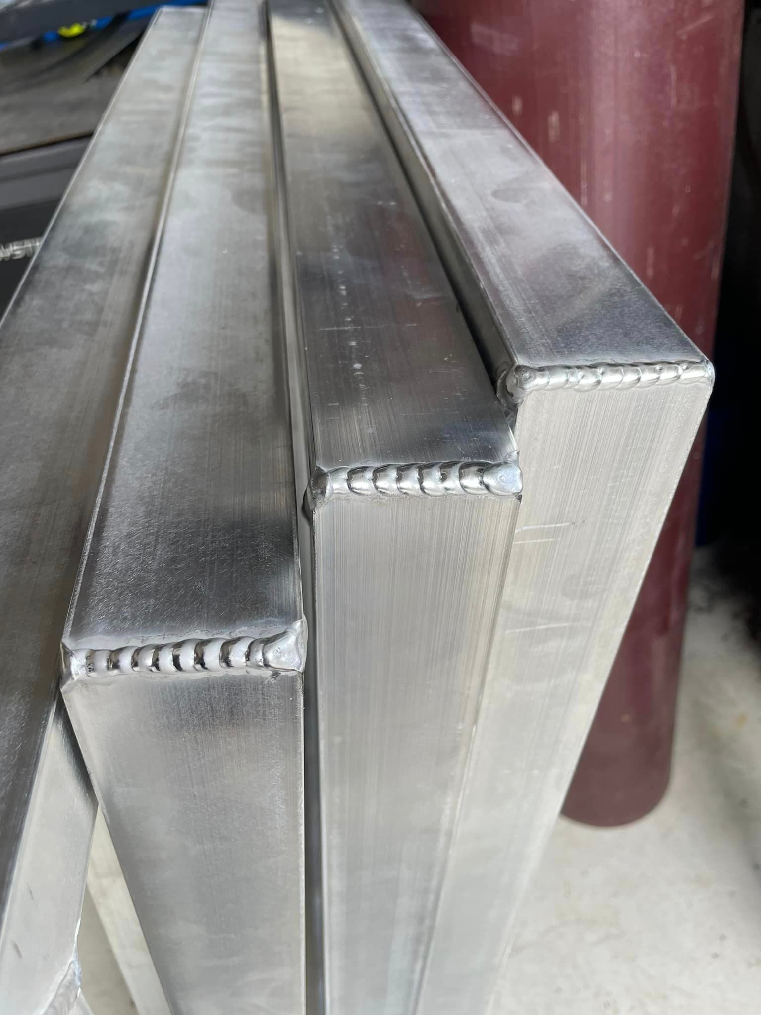 Three silver metal frames with welded corners.