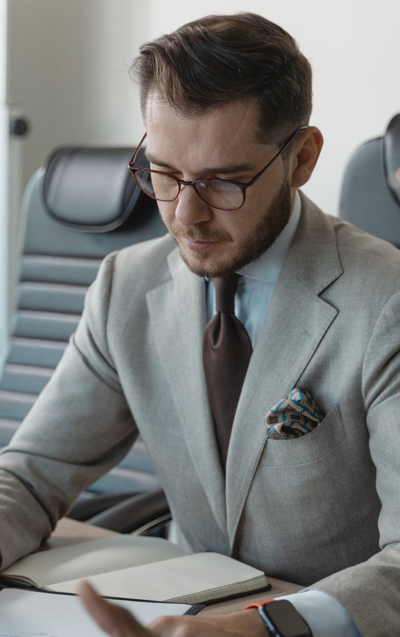 A man in a suit and tie is sitting at a desk.