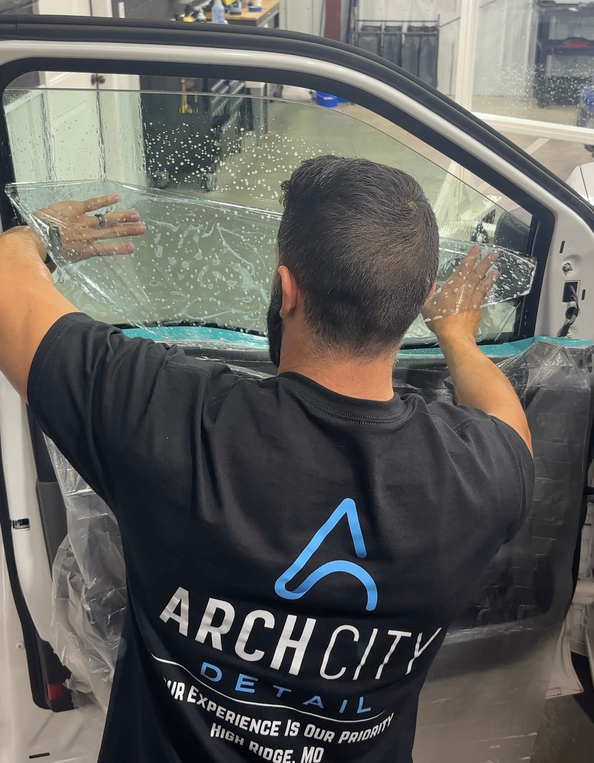 A man installing window tint on a front door.