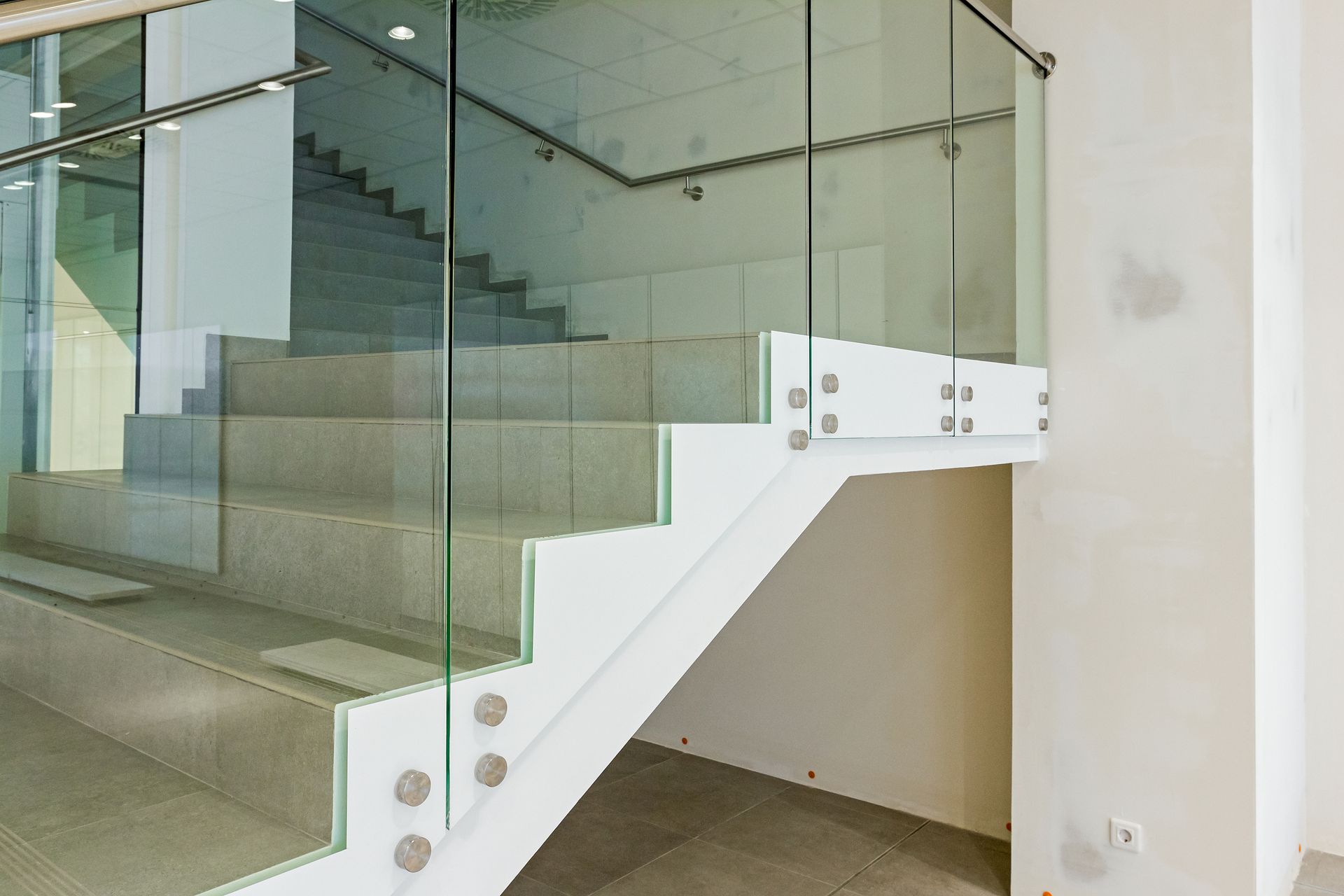 White staircase with glass railing.
