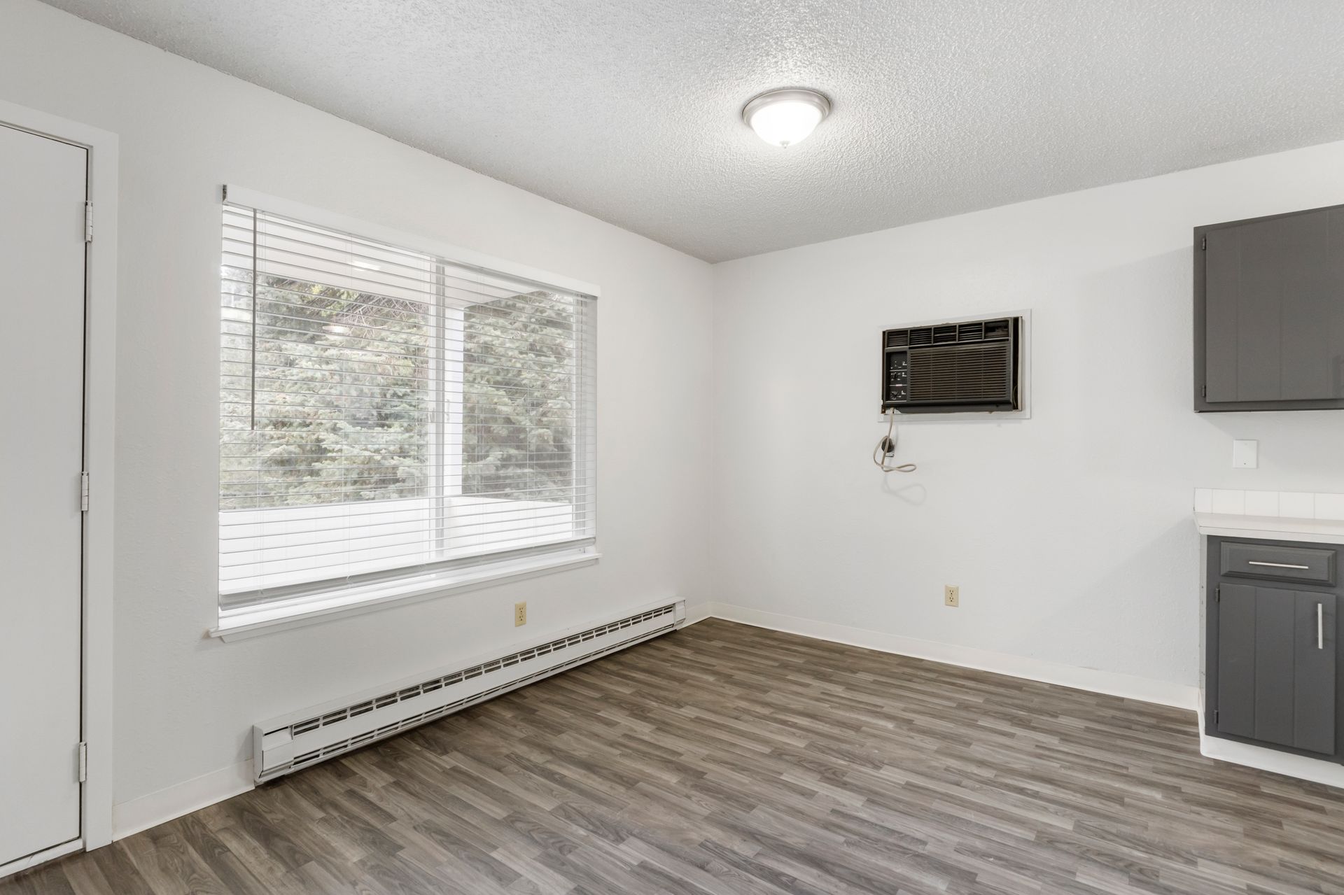 A living room with a large window and a flat screen tv on the wall.