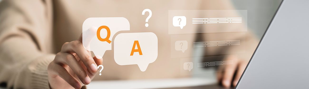 Hands typing on a laptop with orange Q and A speech bubbles on screen