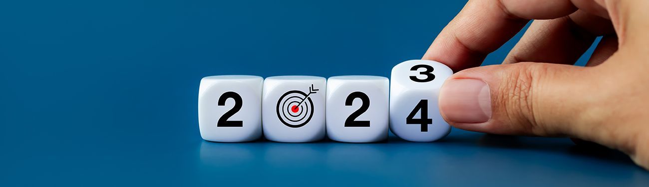 A hand is holding a dice with the number 2024 on it.