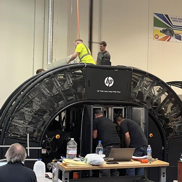 A group of men are working on an hp machine.