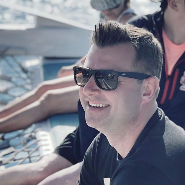 Mat Inkmann sitting on a beach in Sunglasses