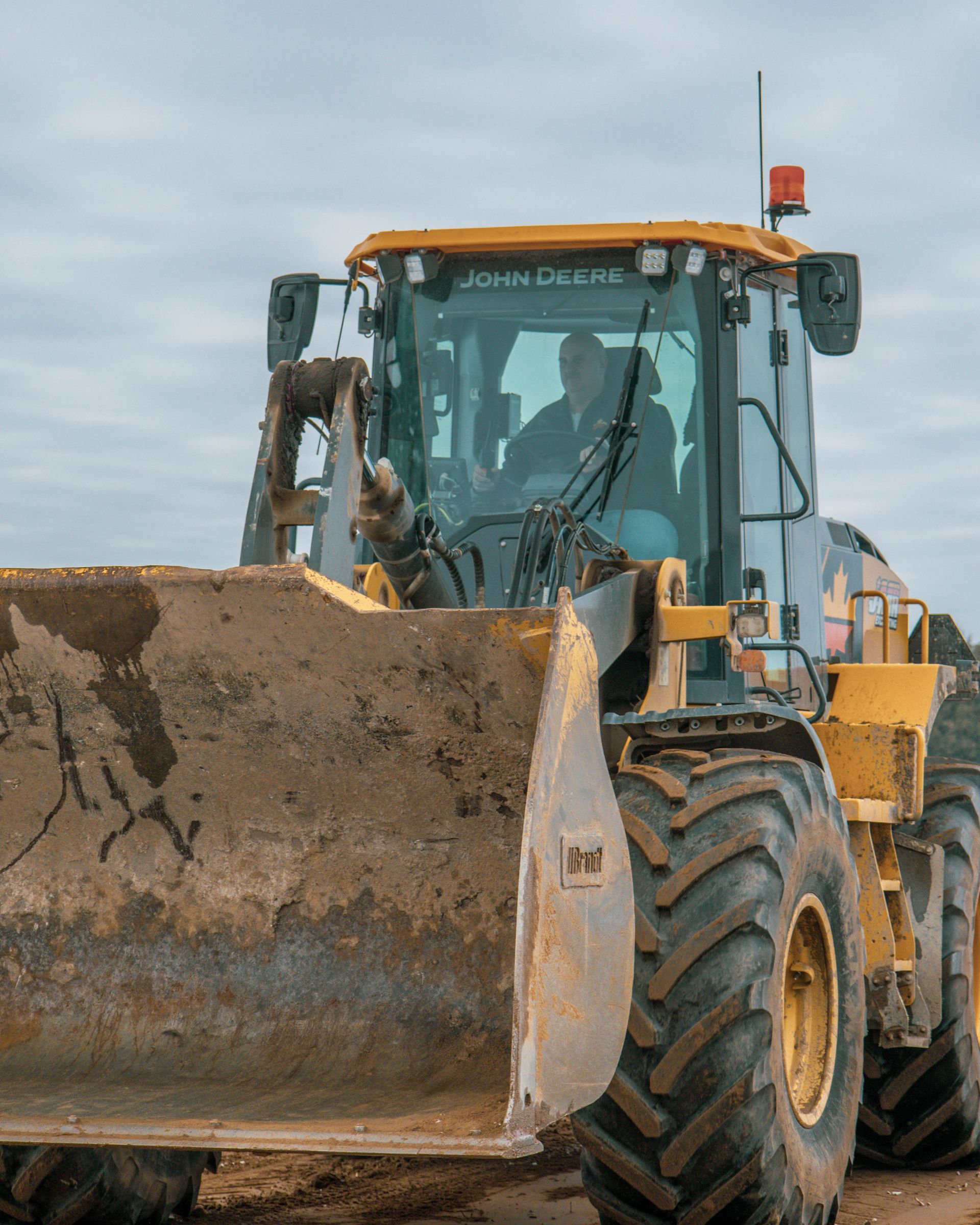 A john deere bulldozer is parked on a dirt road