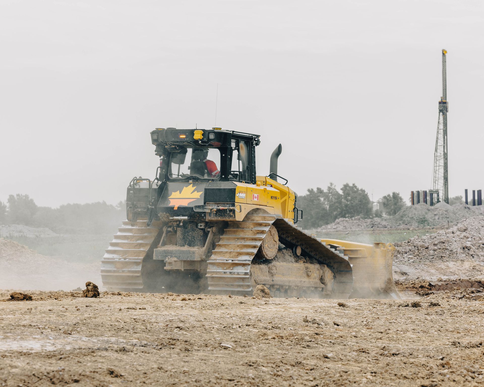 A yellow bulldozer pushing dirt on a construction site.