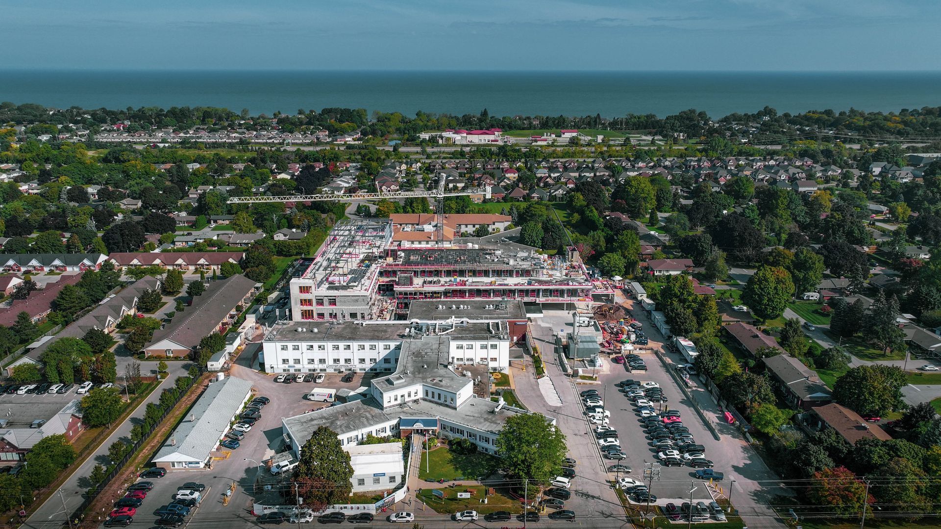 an aerial view of a large building surrounded by trees and a parking lot .