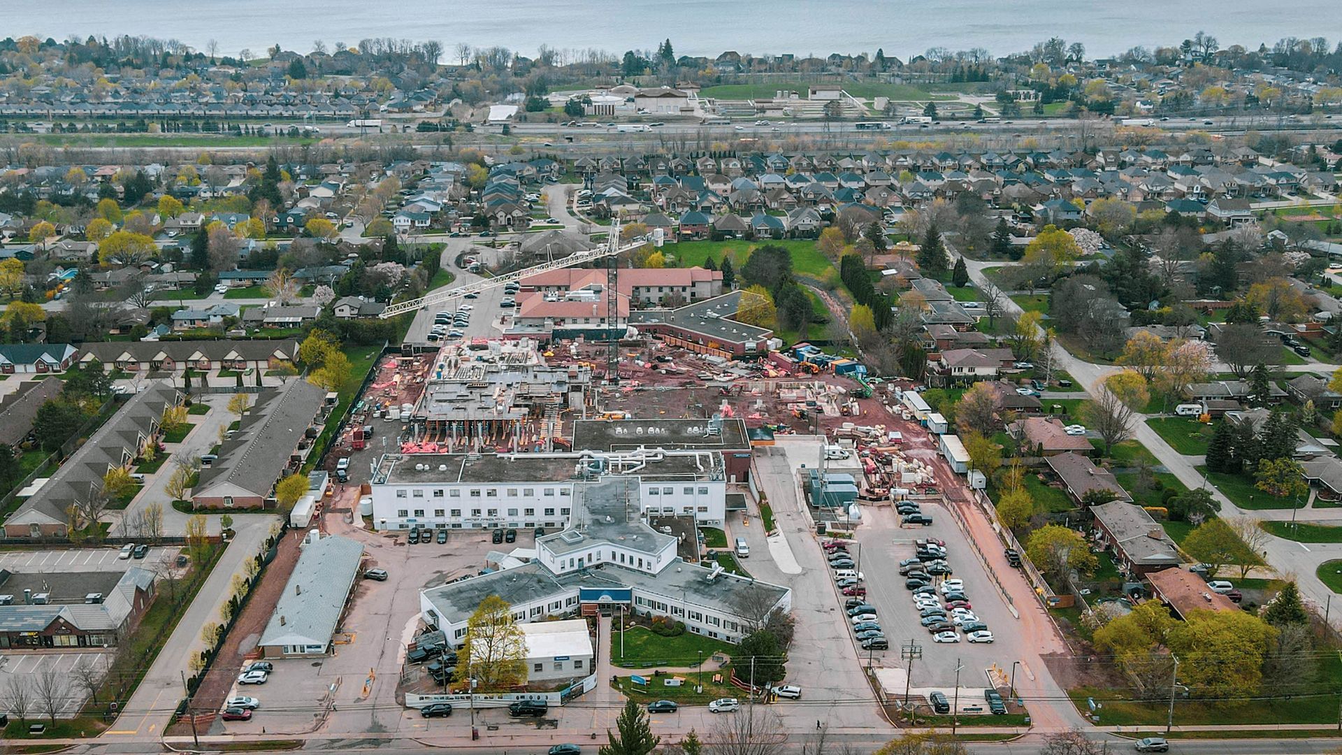 an aerial view of a city with a lot of cars parked on the side of the road .