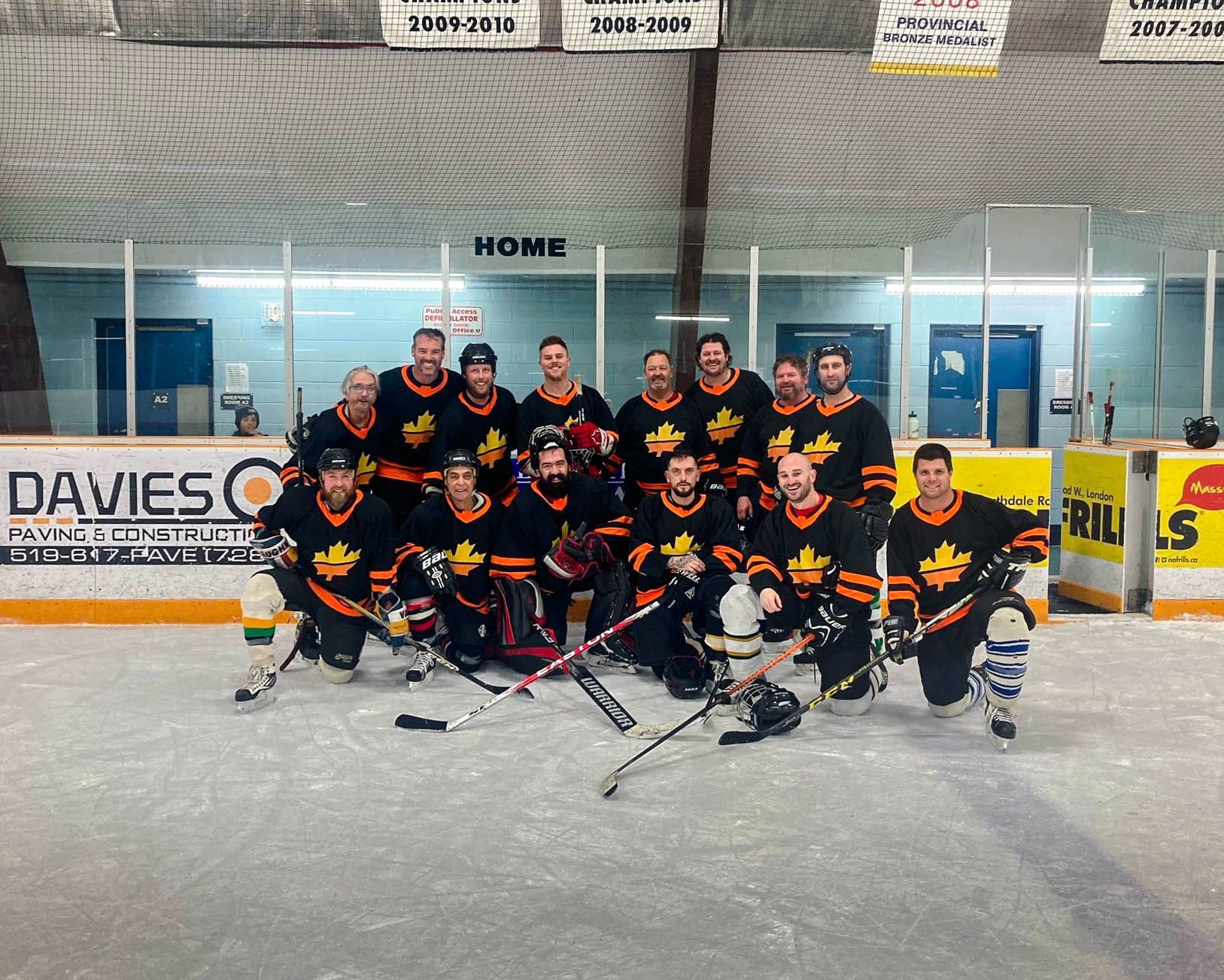a group of hockey players are posing for a picture on the ice .