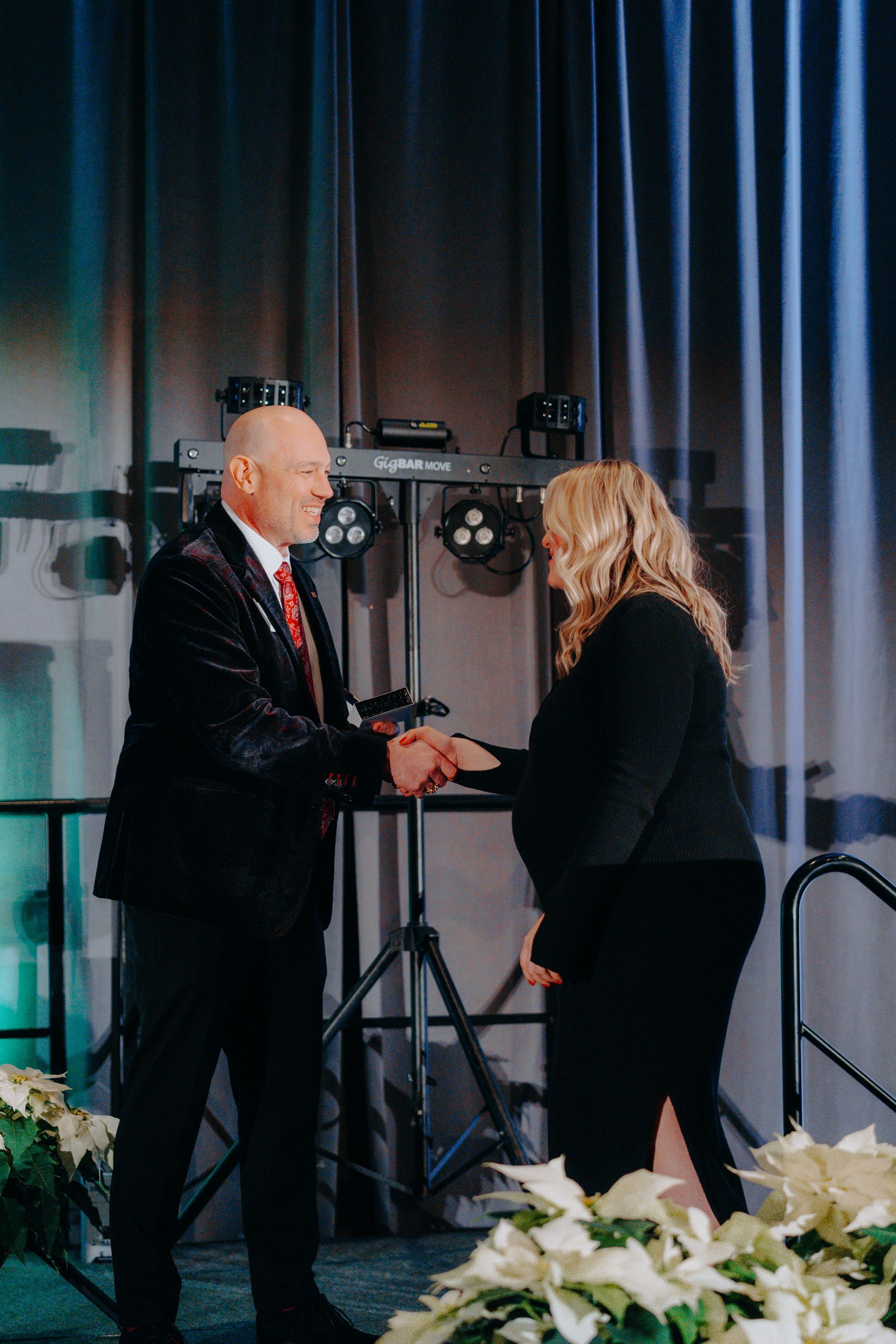 a man and a woman are shaking hands on a stage .
