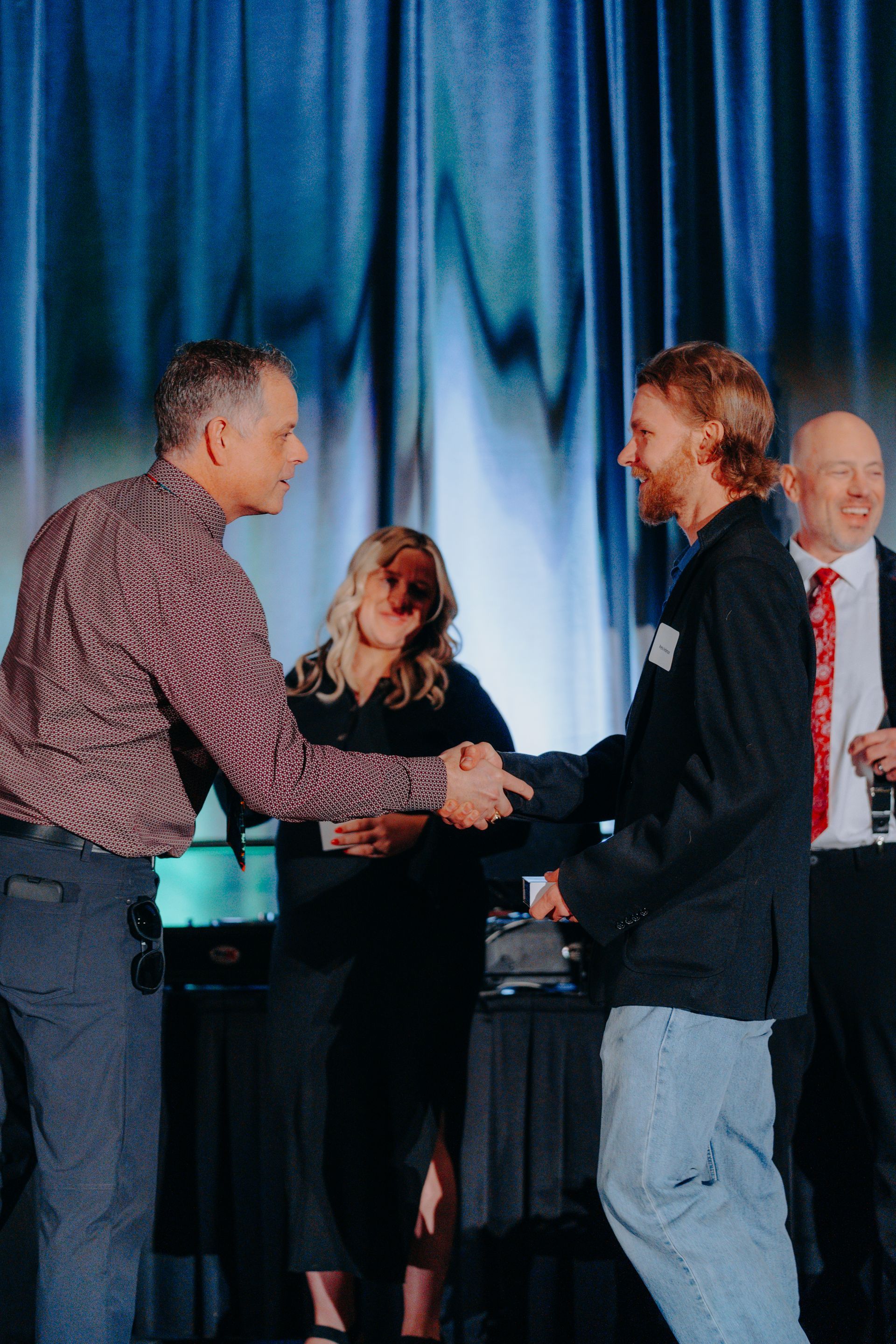 a man is shaking hands with another man on a stage .