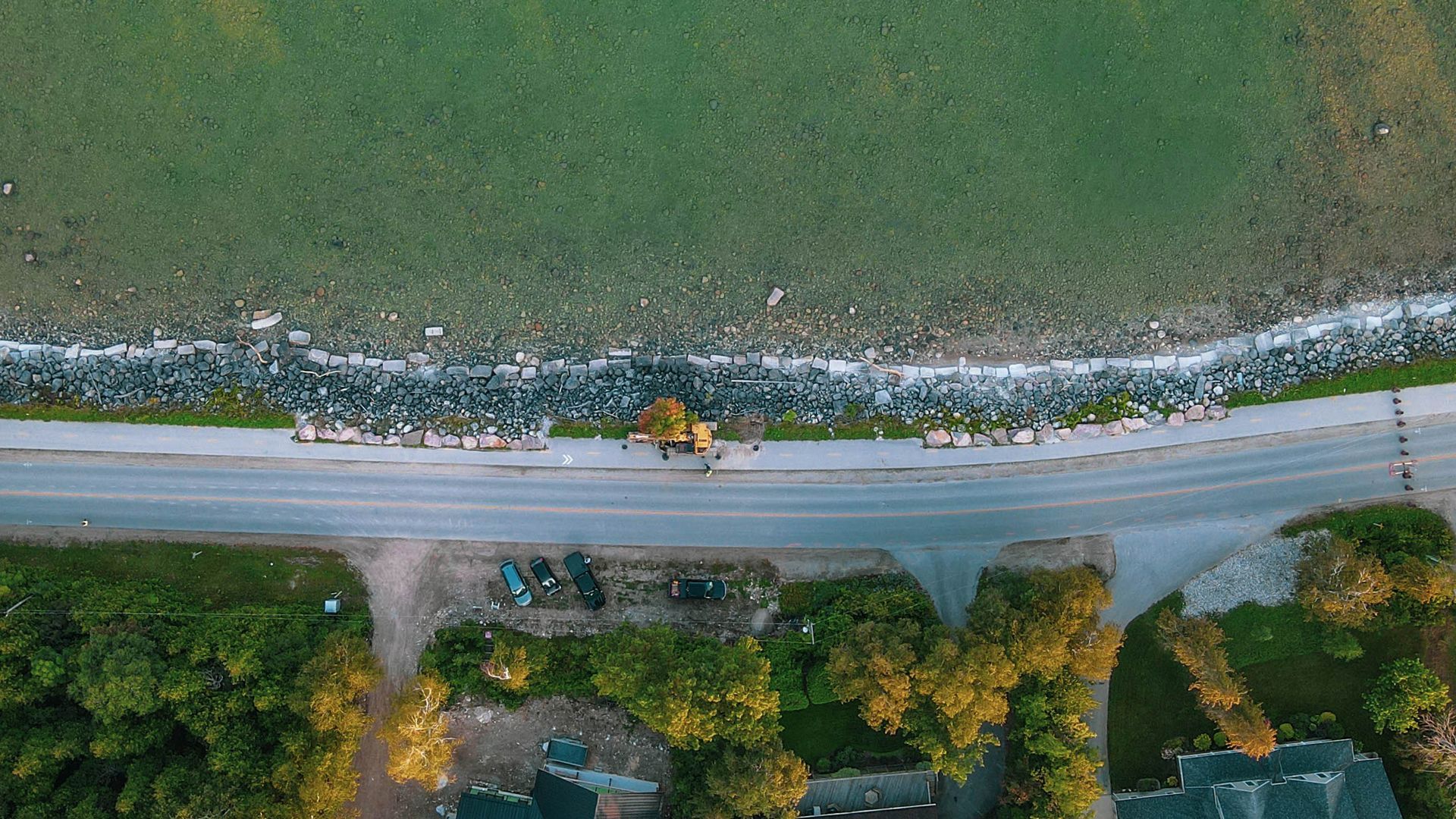 An aerial view of a road next to a body of water.