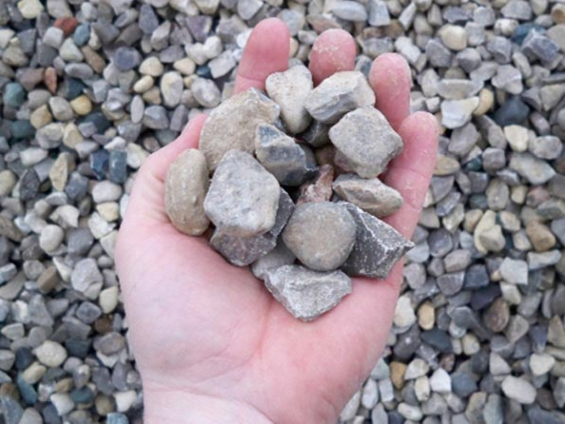a person is holding a pile of rocks in their hand .