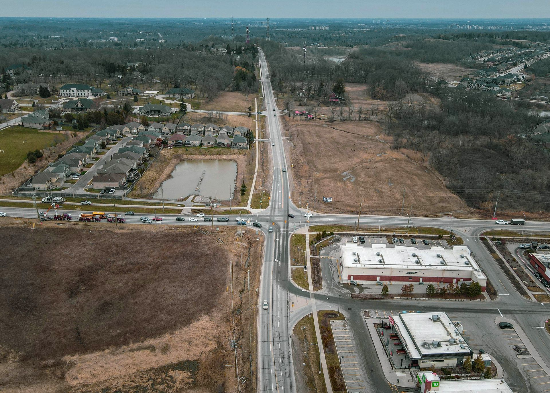 An aerial view of a highway intersection with a store in the middle of it.