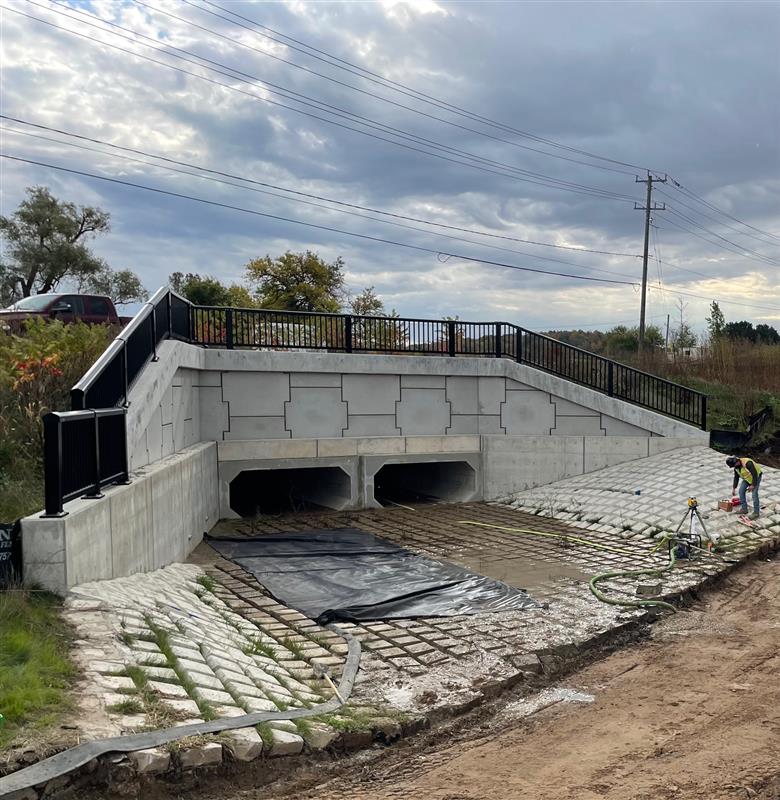 A bridge is being built over a river with a staircase leading up to it.