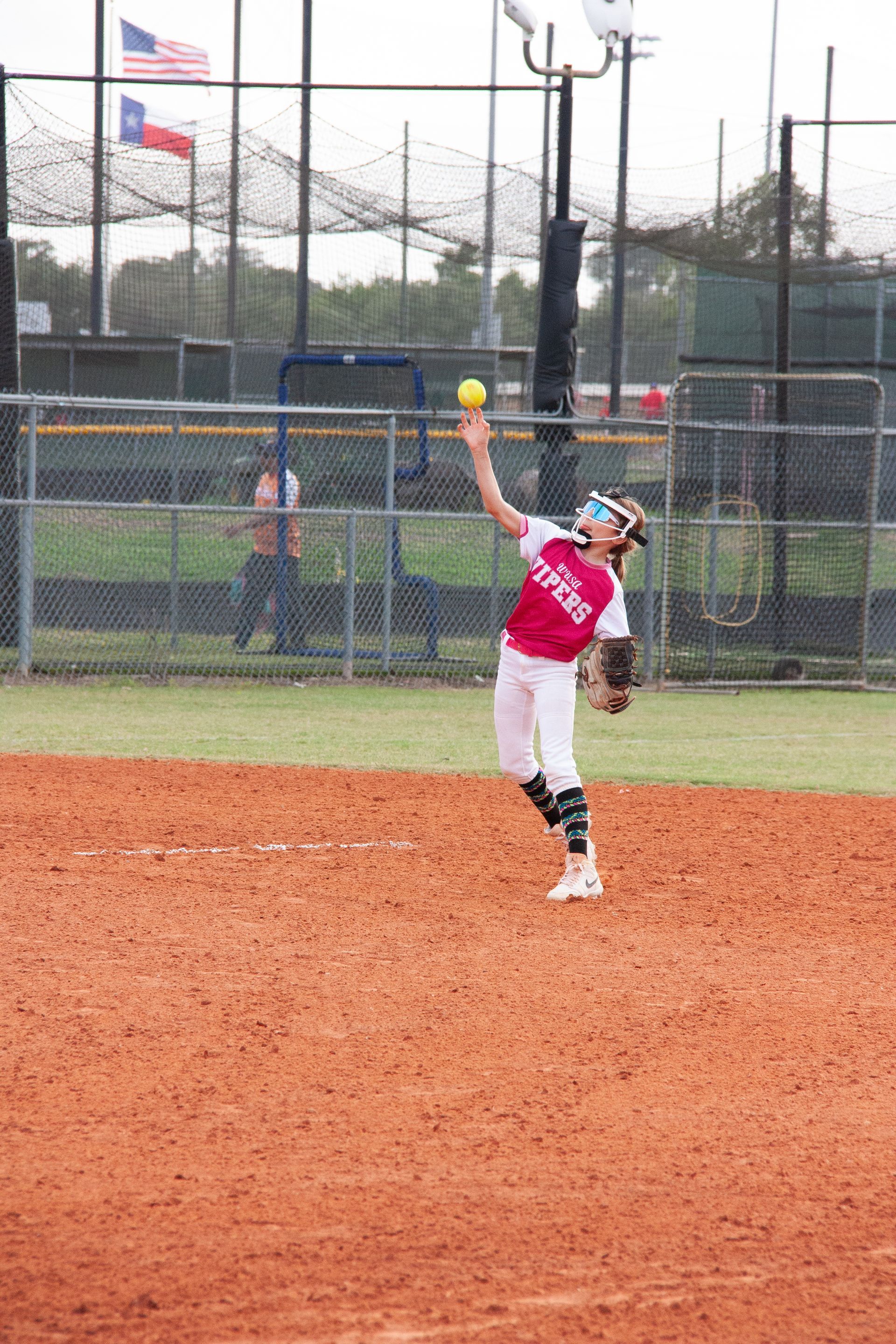 Baseball player sliding into base as another player attempts to catch the ball.